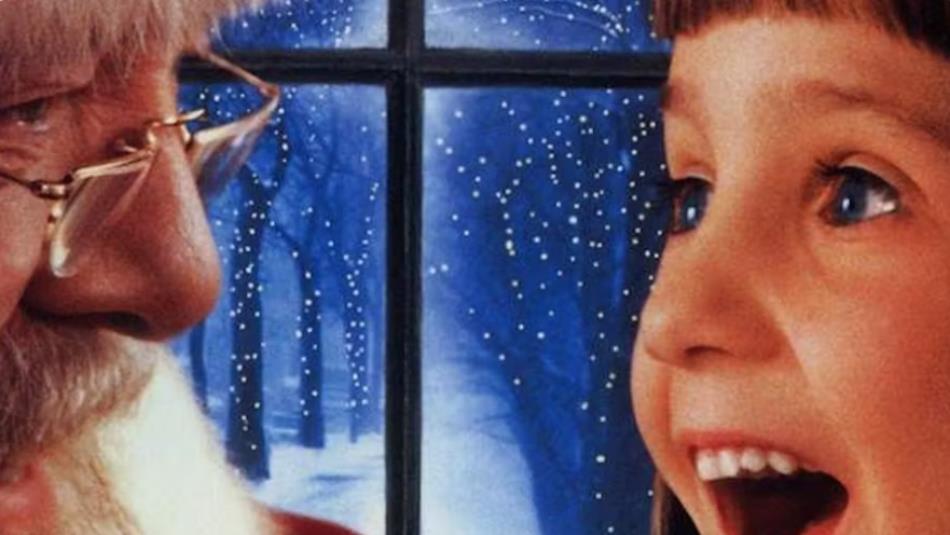 A scene from the Miracle of 34th Street, a small child smiling at Santa with a snowy landscape through a window in the background.