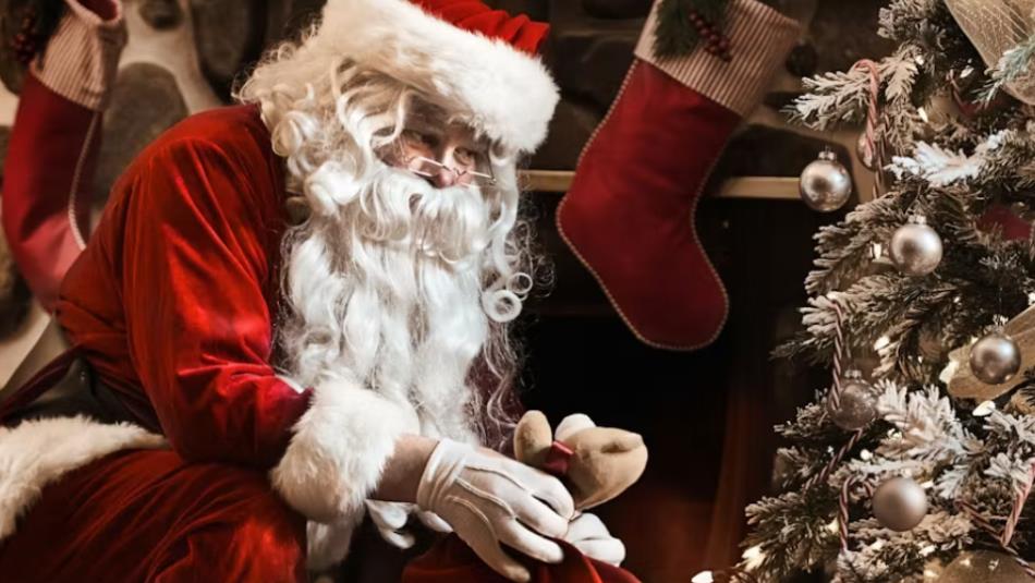 Santa Claus delivering presents under the Christmas tree.