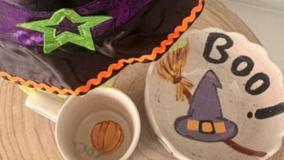 A ceramic mug and bowl painted with a witches hat and pumpkin.