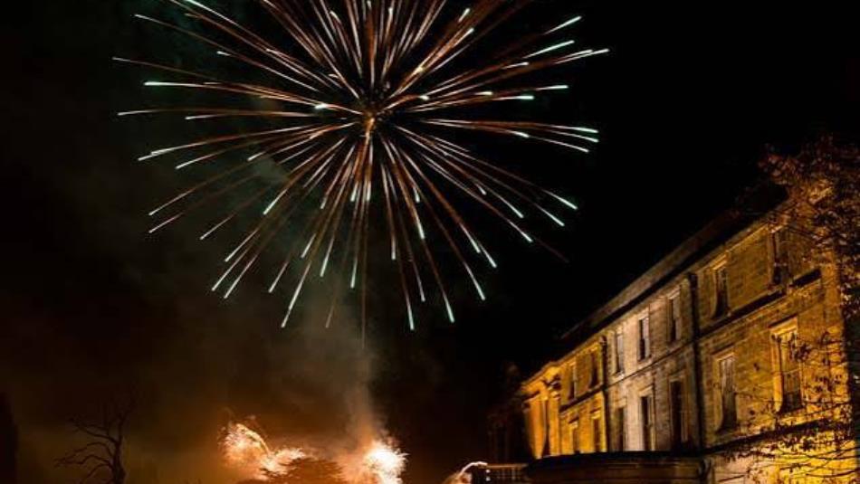 A bright firework over Beamish Hall Hotel in the dark.