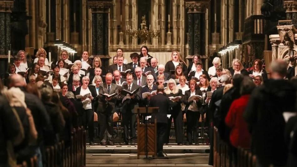 A group of choir singers wearing black and white clothing in Durham Cathedral.