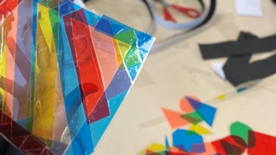 A colourful craft workshop with paper shapes on a table.
