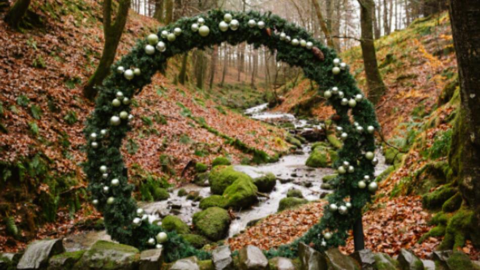A large circular standing wreath in an autumnal forest landscape.