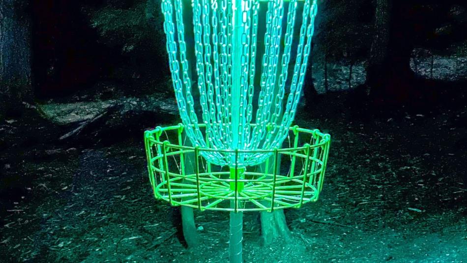 A glowing disc golf course in the dark.
