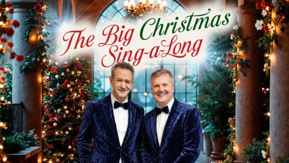 Alexander Armstrong and Aled Jones standing side-by side in blue velvet suits against a festive background.