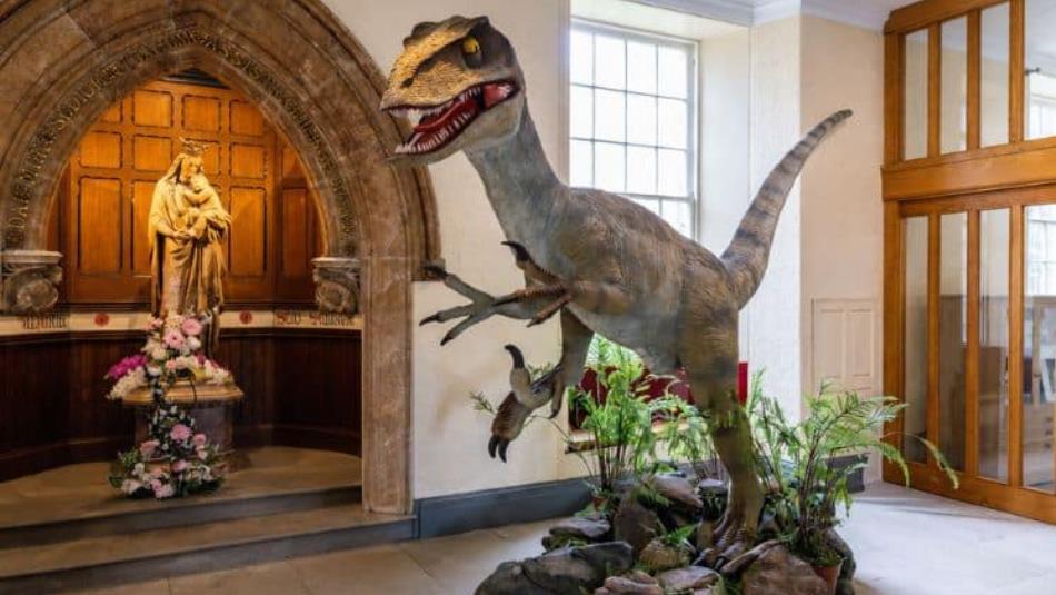 Large sculpture of a Velociraptor dinosaur in the lobby of Ushaw.