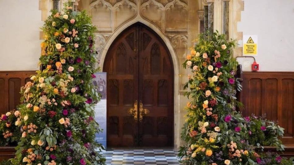 Grand historic door surrounded by beautiful bushes of flowers in Ushaw House.