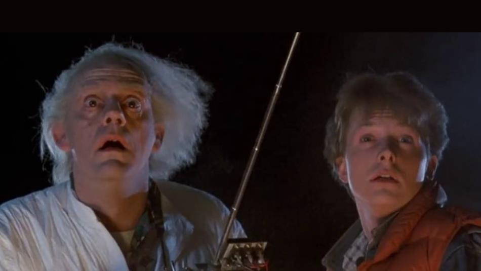 Doc (left) and Marty McFly (right) looking bewildered into the night holding a scientific remote
