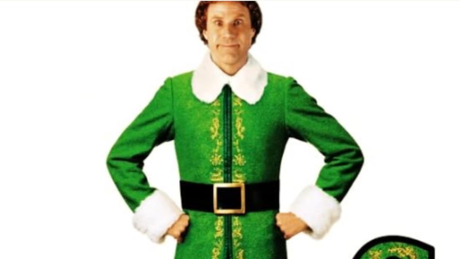Buddy from the film Elf (2003) wearing a green festive outfit, smiling with his hands on his hips, on a white background