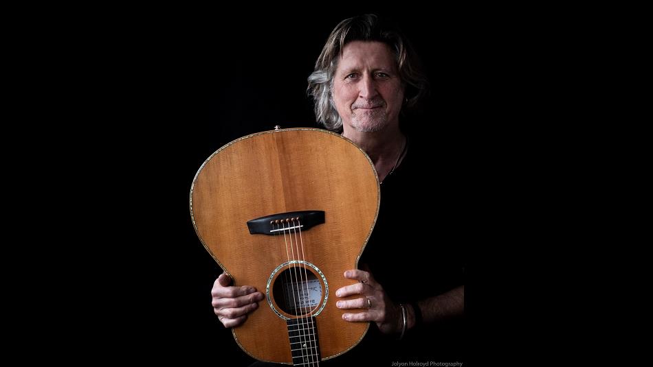 Steve Knightley holding a guitar upside down