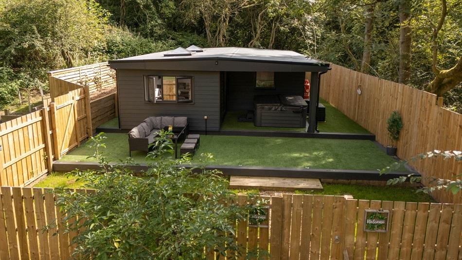 Exterior image of 'The Oak', Beamish Glamping, in a woodland location, showing the outdoor seating area.