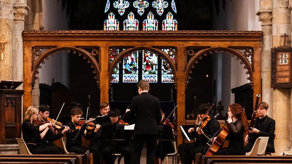 Durham student orchestra performing in St Oswald's Church, Durham City.