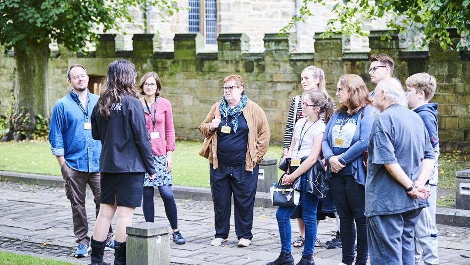 A group of people on a guided tour of Durham World Heritage Site