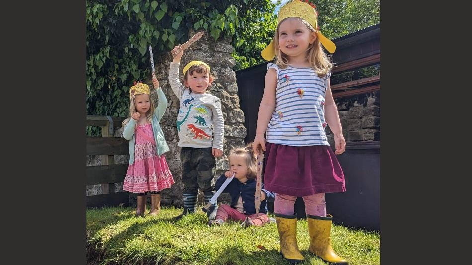 4 young children with craft Roman helmets and swords that they have made