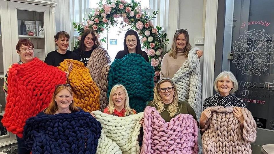 A group of women displaying their and knitted blankets