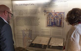 Two people looking at the 1216 Magna Carta at Durham Cathedral Museum