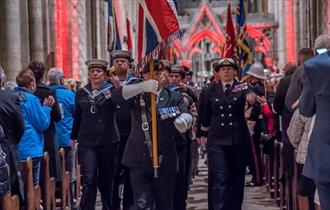 Festival of Remembrance service in Durham Cathedral with members of the armed forces marching down the Nave with the Union Jack held high