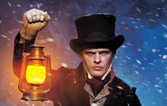A character from A Christmas Carol, a man holding a lantern.