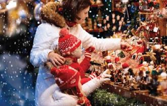 Woman and child looking at a stall display Christmas decorations.