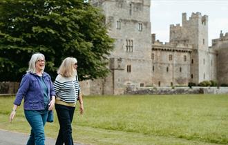 Two women walking in the grounds of Raby Castle