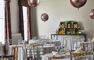 A room at the Durham Marriott set up for a Christmas Party with balloons and table decorations