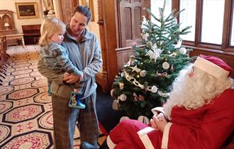 Santa Claus greeting a child at Ushaw