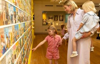 A woman and her two children looking at the Ladybird Exhibition at Ushaw.