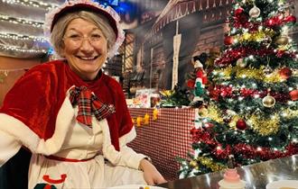 Mrs Claus sitting beside the Christmas Tree at Adventure Valley