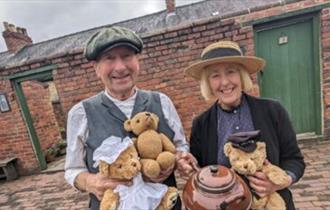 staff at Beamish, The Living Museum of the North dressed in costume and holding teddy bears.