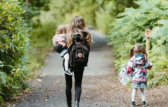 Mother and daughters doing an activity trail at High Force Waterfall. Black backpack.