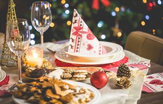 Table at Bowburn Hall set for Christmas Day Lunch with Christmas decor, treats, wine and candles.