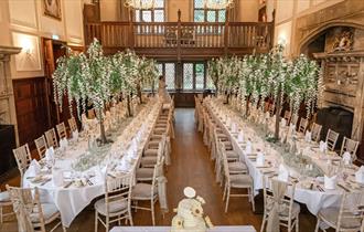 2 tables, banquet style, beautifully decorated for a wedding.