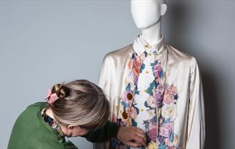 Rachel Whitworth, Curator of Fashion & Textiles, adjusting clothing on a mannequin ©ClaireCollinsonPhotography