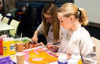 Image of two children enjoying painting.