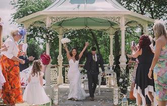 Guests throwing confetti over newly married couple.