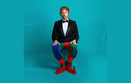 Mark Simmons dressed in a dinner jacket with Jester's trousers and shoes
