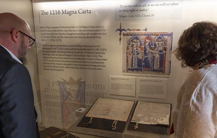 Two people looking at the 1216 Magna Carta at Durham Cathedral Museum