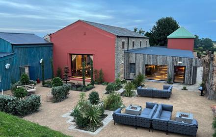 Exterior of Runa Farm with outdoor seating and shrubs