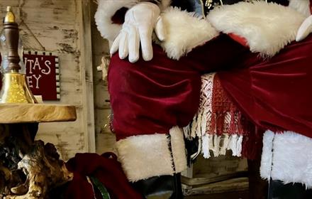 Close up of Santa's legs sitting on a chair.