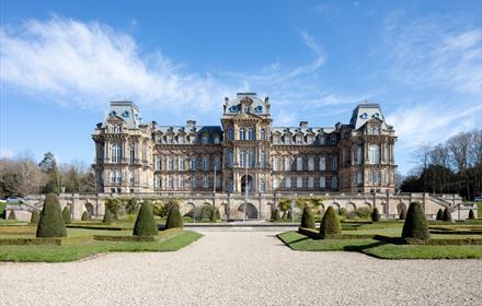 The exterior of The Bowes Museum and its grounds on a sunny day.