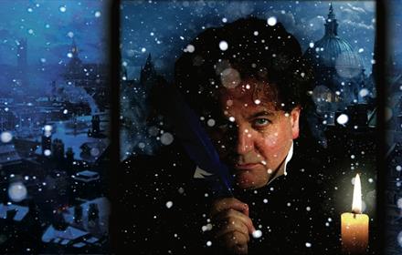 Image of Ebenezer Scrooge lit by candlelight in a snowy window