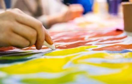 Image of someone colouring a canvas.