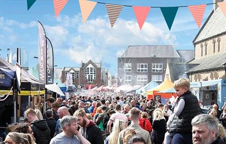 Crowds of people attending Bishop Auckland Food Festival, Market Stalls, bunting