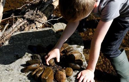 Boy making a design/pattern with rocks