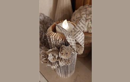 Candle holder made from folded pages from a book.