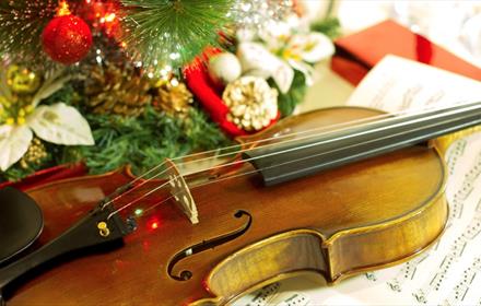 Violin, sheet music and Christmas decorations