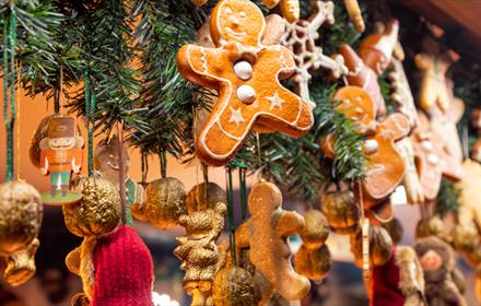 Christmas decorations such as gingerbread hanging from Christmas stall at Christmas Fair.