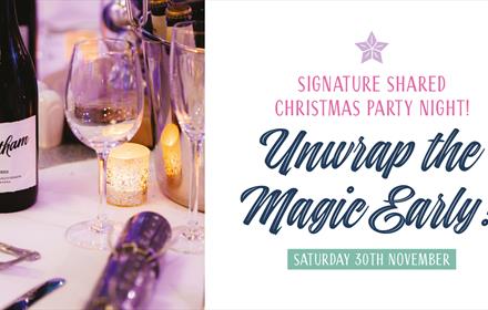 Text reads 'Unwrap The Magic Early' alongside a bottle of wine, crackers and candles