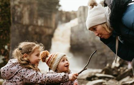Image of a family playing with twigs at High Force