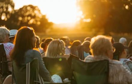 An audience watching outdoor cinema at Raby Castle